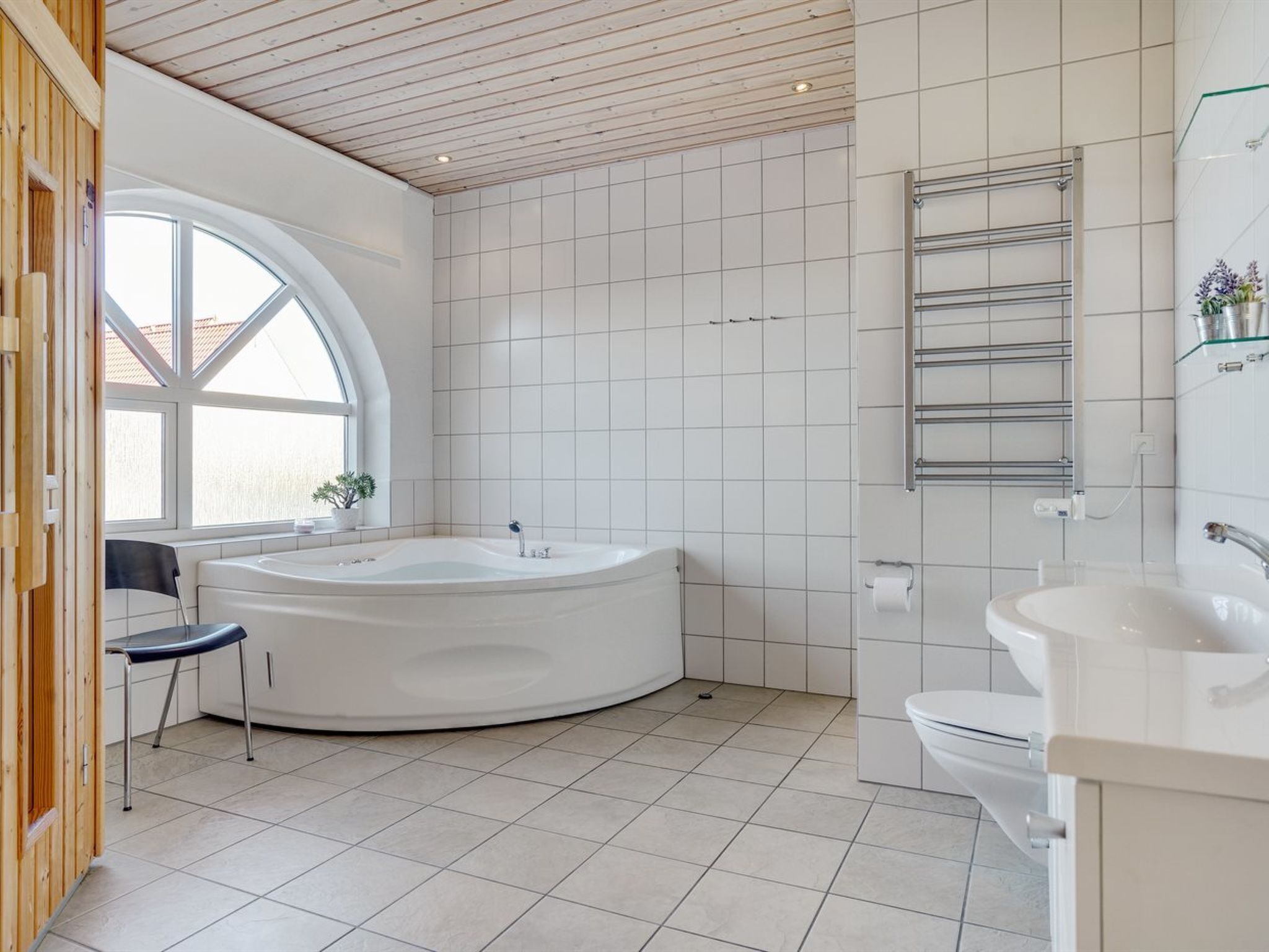 Une salle de bain moderne avec une baignoire sur pieds, un lavabo et une fenêtre.