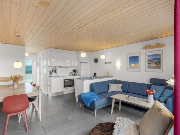 A modern living space with a kitchen, dining area, and seating area.
