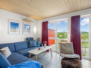 Un salon moderne avec un canapé, une table basse et une vue sur l’extérieur.