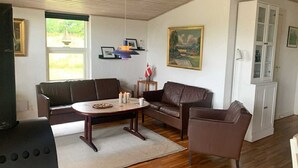 Un salon avec un canapé en cuir marron, une table basse et un meuble.