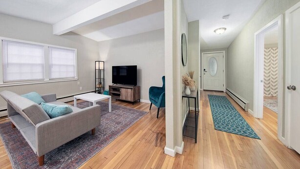 Un salon moderne avec un canapé, un téléviseur et une petite table.