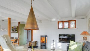 Una sala de estar acogedora con chimenea, un sofá, una mesita de centro y un televisor.