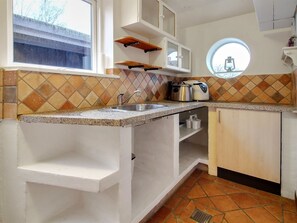 Een koelkast, een magnetron, een vaatwasser, kookgerei, borden en bestek