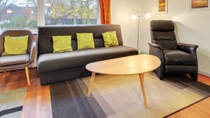 A modern living room with a sofa, two armchairs, a wooden coffee table, and a floor lamp. - "Claudia" by Interhome (Bredebro)