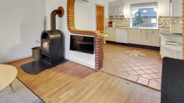 A modern kitchen with a built-in wood stove, a dining area, and a kitchen island. - "Claudia" by Interhome (Bredebro)