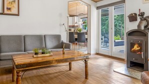 En hyggelig stue med et træbord, en grå sofa og en pejs.