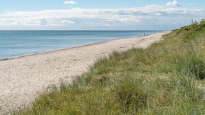 En strand med klart skys og roligt hav.