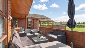 Ein überdachter Außenbereich mit Korbmöbeln und einer Pergola.