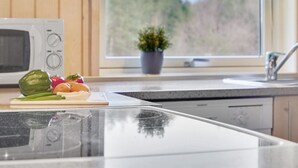 A kitchen with a microwave, a sink, and a window with a view of trees. - "Lisel" - 25km from the sea by Interhome (Toftlund)
