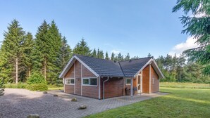 A single-story wooden cabin with a sloped roof, a covered porch, and a gravel driveway. - "Lisel" - 25km from the sea by Interhome (Toftlund)