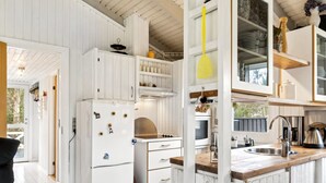 A compact kitchen with white cabinetry, a built-in oven, and a sink. - "Alvine" - 475m from the sea by Interhome (Jerup)