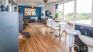 Una cocina moderna con comedor, ventanas amplias y vistas a la vegetación.