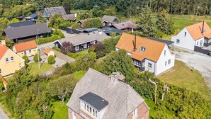 Vue aérienne d’un quartier résidentiel avec des maisons, des routes et un paysage boisé.