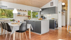 A modern kitchen with a dining area, wooden ceiling, and large windows. - "Barne" - 4km from the sea by Interhome (Sæby)