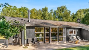 A modern house with a large glass extension, outdoor seating, and a chimney. - "Barne" - 4km from the sea by Interhome (Sæby)