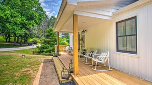 A covered porch with wooden flooring, white rocking chairs, and a large window. - Relax at a peaceful farmhouse near Nelson 151 featuring three king bedrooms, a brand-new private hot tub, fire pit, and inviting gathering spaces—just minutes from wineries, breweries, hiking, and Blue Ridge adventures. (Afton)