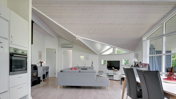 Una cocina moderna con electrodomésticos integrados, un comedor con mesa y sillas, y un amplio ventanal que proporciona luz natural.