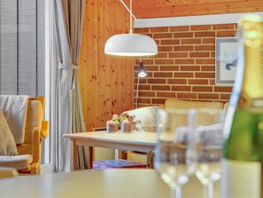 Una habitación acogedora con una pared de madera, una mesa con lámpara y una silla.
