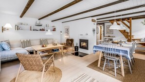 A spacious living room with a fireplace, a dining area with a table and chairs, and a cozy seating area with a sofa and chairs. - "Alkil" - 1.7km from the sea by Interhome (Ulfborg)