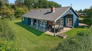 Une maison à deux étages avec un patio couvert et une pelouse.