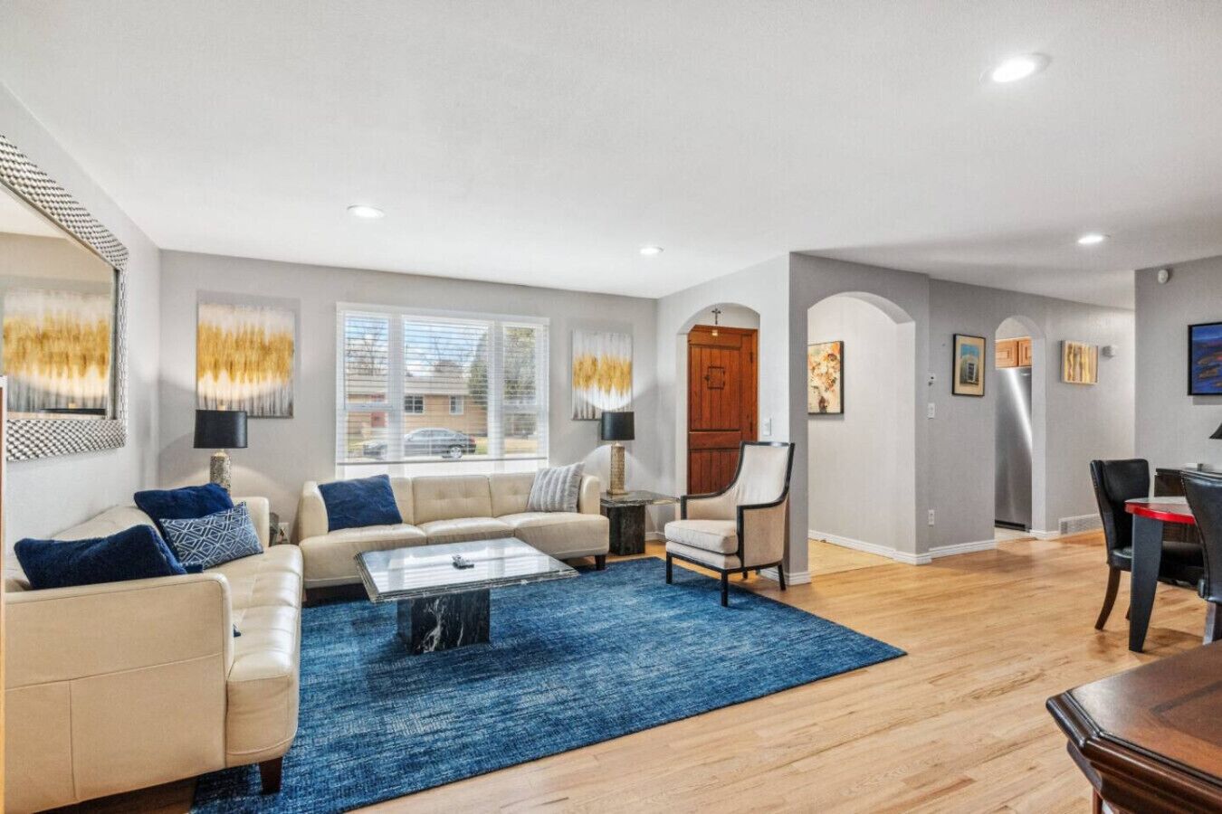 A spacious living room with a sofa, coffee table, and a dining area with chairs and a table.