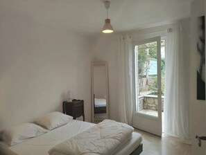 Cozy retreat with a single bed, bedside table, and mirror.