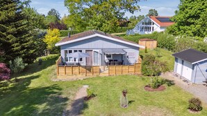 A single-story house with a covered patio, a fenced yard, and a small shed. - "Ømund" - 600m to the fjord by Interhome (Holbæk)