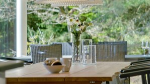 A dining table with a vase of flowers, a bowl of pastries, and two glasses of water. - "Rikkie" - 150m to the fjord by Interhome (Rørvig)
