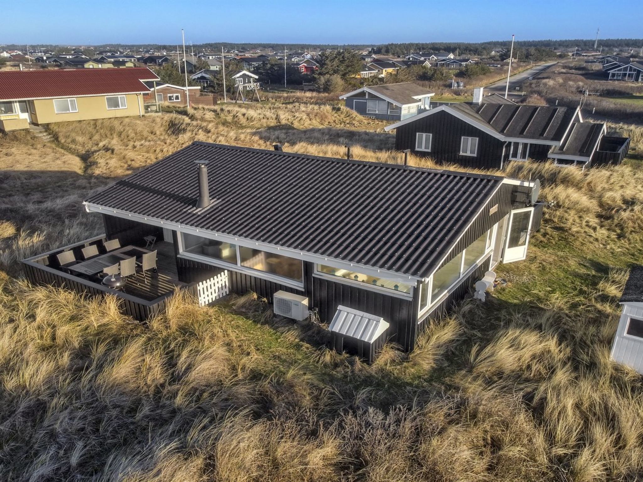 Une maison moderne avec un toit plat, de grandes fenêtres et une terrasse.