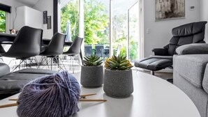 A modern living room with a grey sofa, a round coffee table, and a potted succulent plant.