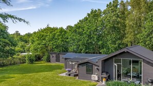 A modern house with a well-maintained lawn and a patio area.
