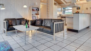 A modern interior with a sofa, a dining table, and a kitchen area.