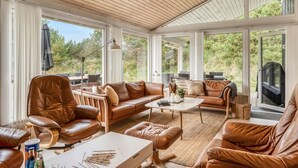 A spacious sunroom with leather furniture, large windows, and a view of the outdoors. - "Helene" - 1.5km from the sea by Interhome (Blokhus)