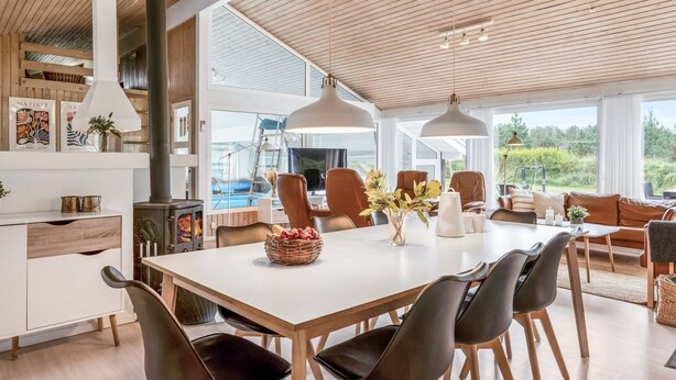 A modern kitchen with a large dining table, wooden chairs, and a built-in stove. - "Helene" - 1.5km from the sea by Interhome (Blokhus)