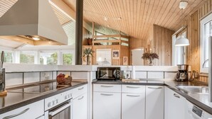 A modern kitchen with white cabinetry, a built-in oven, a microwave, and a coffee maker. - "Helene" - 1.5km from the sea by Interhome (Blokhus)