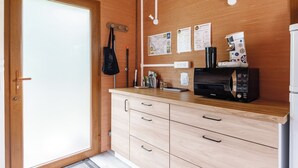 Una cocina compacta con muebles de madera, una cafetera y una pequeña encimera.