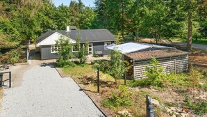 A single-story house with a grey roof, surrounded by trees and a gravel driveway. - "Tannie" - 300m from the sea by Interhome (Strøby)