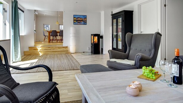 A modern living room with a grey armchair, a wooden coffee table, and a dining area in the background. - "Tannie" - 300m from the sea by Interhome (Strøby)