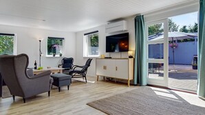 A modern living room with a sofa, chairs, a TV, and a dining area. - "Tannie" - 300m from the sea by Interhome (Strøby)