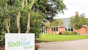 A sign for Stadil Fjord Resort with a view of a building and trees in the background. - "Martinus" - 5.5km from the sea by Interhome (Tim)
