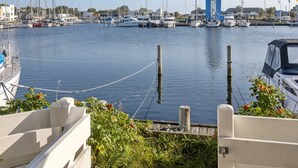 A marina with boats docked, a lighthouse, and a clear sky.