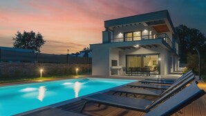 A modern two-story house with a swimming pool, lounge chairs, and a well-lit patio area. - Artsi in Svetvin Enat (Svetvincenat)