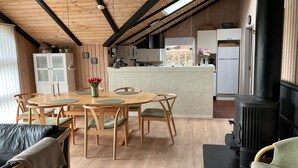 A cozy interior with a dining area, kitchen, and a wood-burning stove. - "Thorgot" - 400m from the sea by Interhome (Sydals)