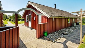 A red building with a tiled roof, a covered outdoor seating area, and a small garden. - "Thorgot" - 400m from the sea by Interhome (Sydals)