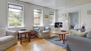 Un salon spacieux doté de planchers en bois franc, de deux canapés, d’une table basse et d’un téléviseur.