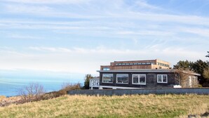 Een modern huis met twee verdiepingen en uitzicht op de oceaan.