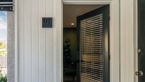 A white exterior wall with a door labeled "01 Suite" and a black doormat with "hello" on it.
