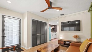 A modern living room with a wooden coffee table, a brown sofa, and a ceiling fan.