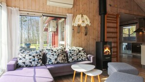 Un salon chaleureux avec un canapé, des poufs et une cheminée.