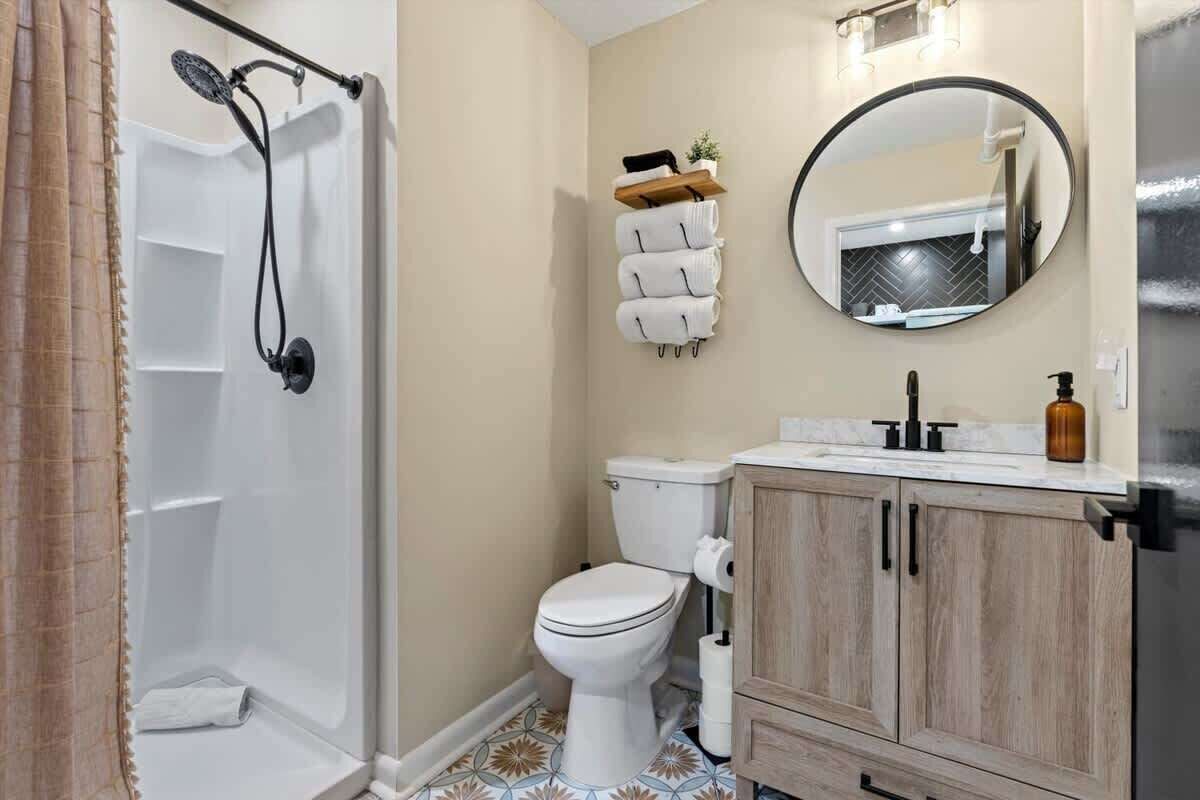 Une salle de bain avec douche, toilettes et lavabo.
